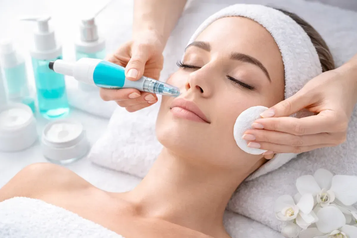 Durante un tratamiento facial, una cosmetóloga utiliza un dispositivo de succión manual en el rostro del paciente.