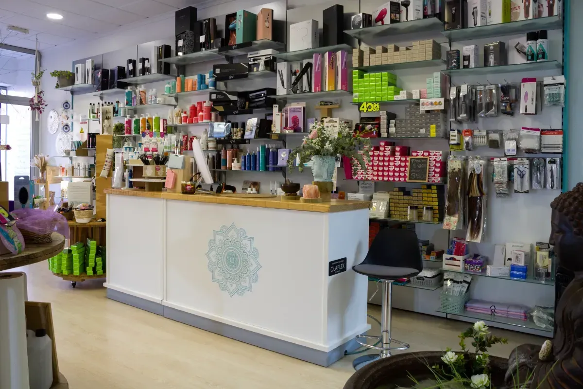 Un mostrador de recepción blanco con un diseño de mandala circular dentro de una tienda con estantes llenos de  productos