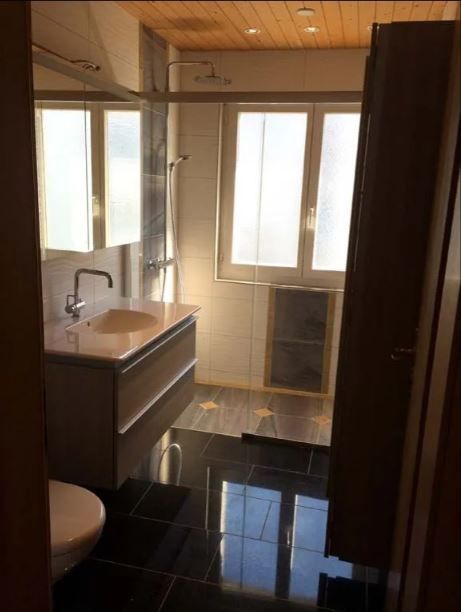 Ein Bad mit schwarzen, glänzenden Marmorfliesen