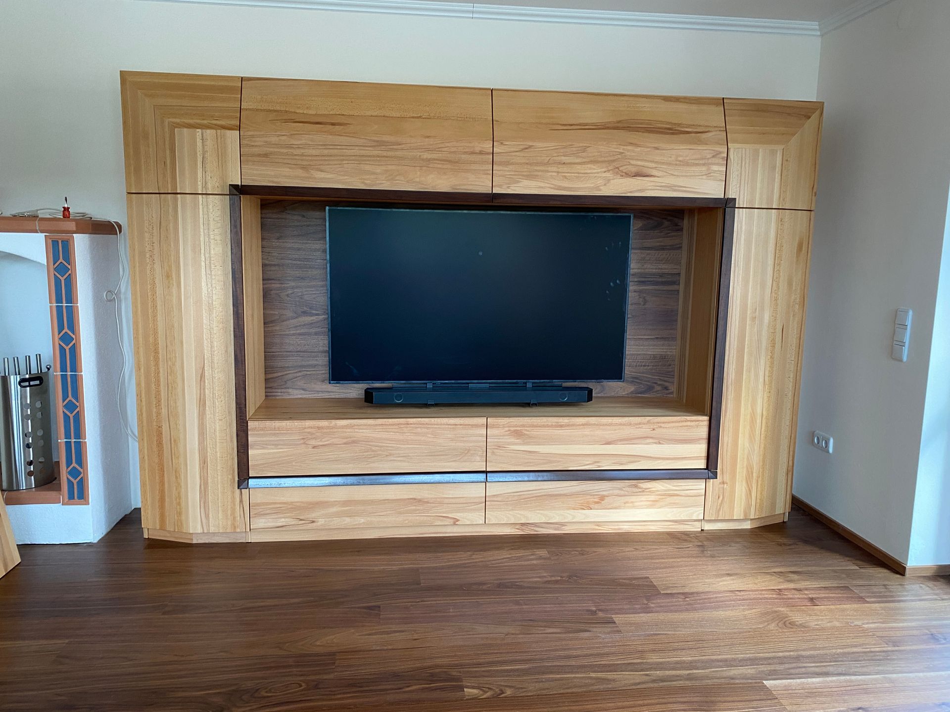 Entertainment-Center aus Holz mit Fernseher und Soundbar.