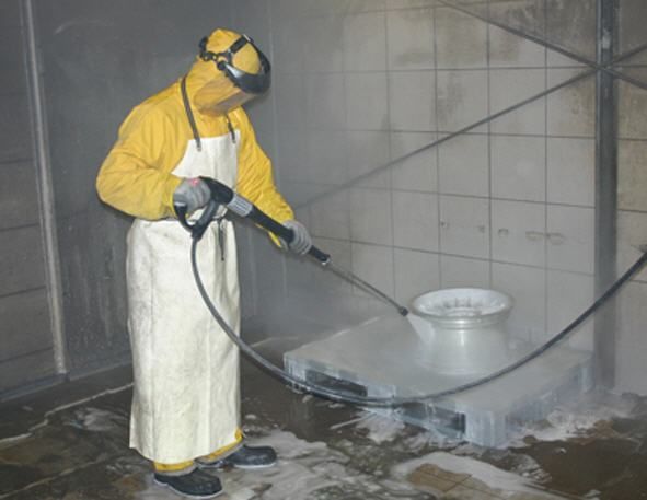 Ein Mann in einer gelben Jacke und Schürze bedient einen Hochdruckreiniger.