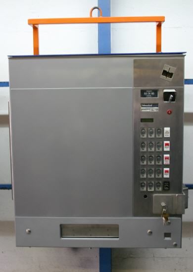 Ein graues Aufzugsbedienfeld hängt an einem Kran