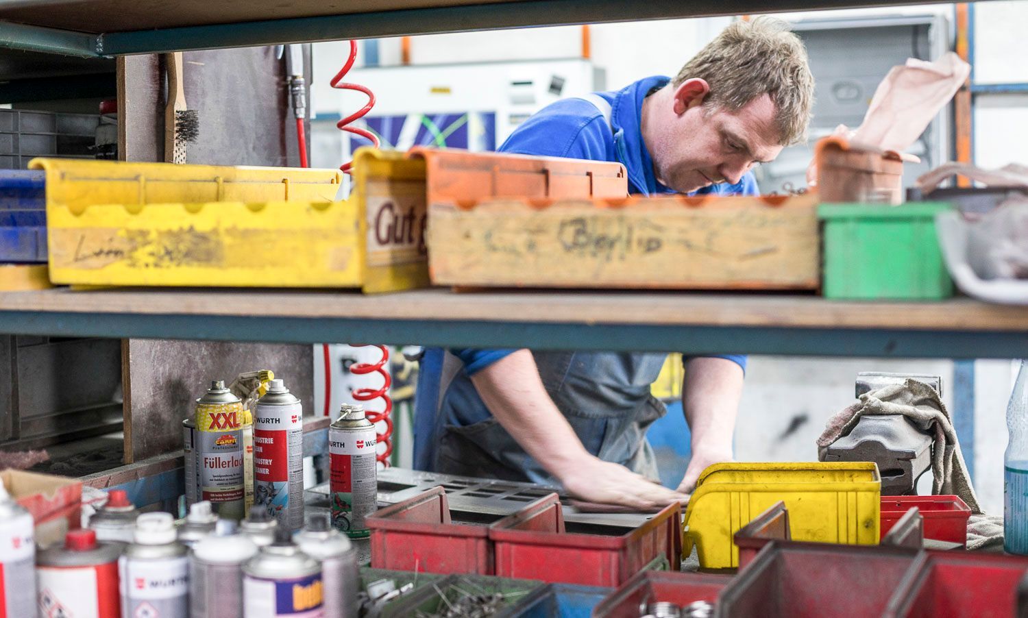 Ein Mann arbeitet in einer Garage an einem Gerät.