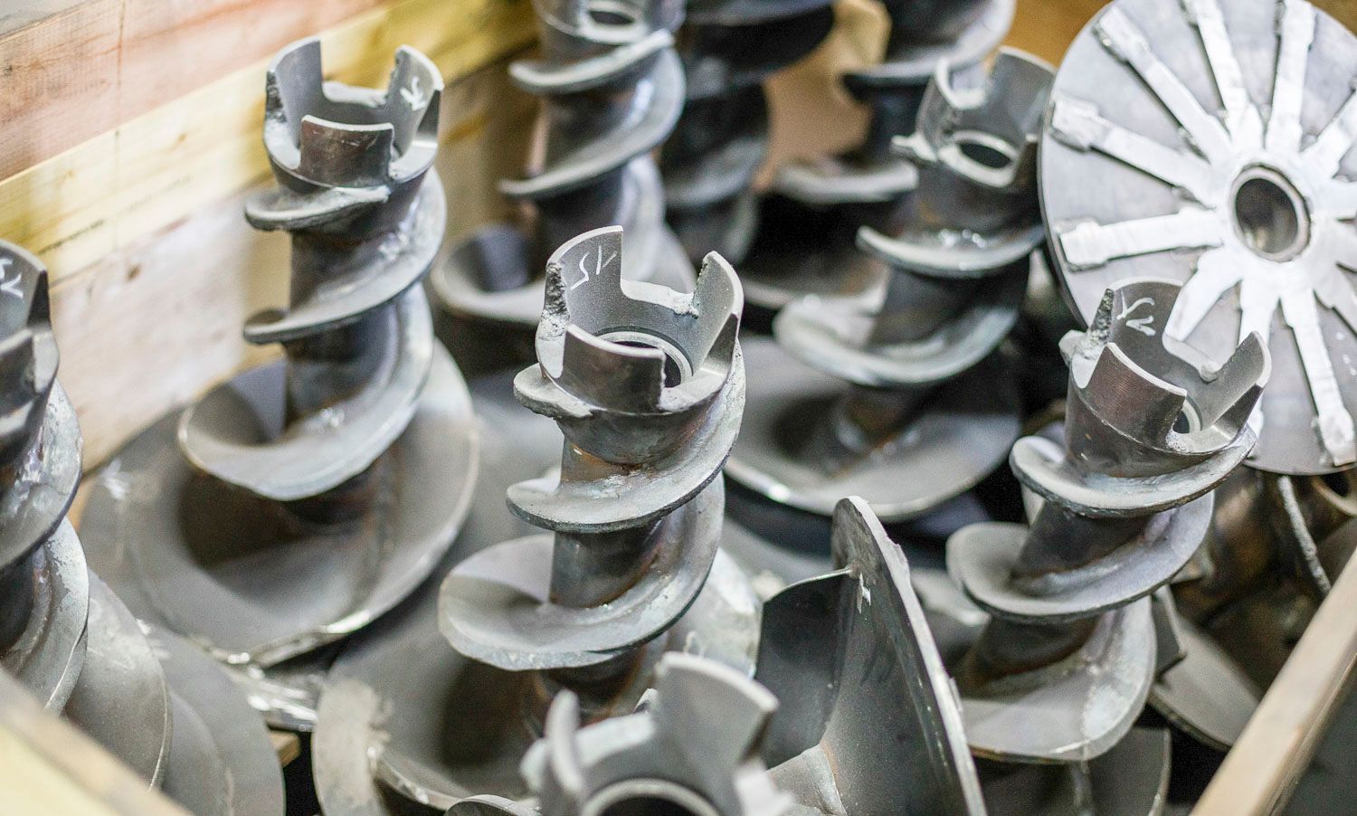 Ein Bündel Metallspiralen liegt in einer Holzkiste.