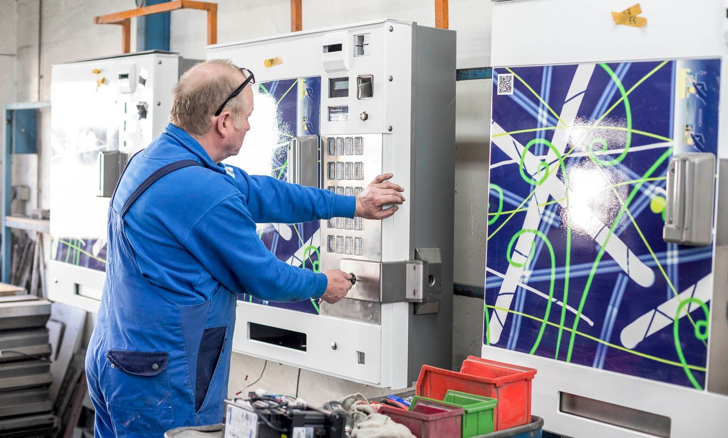 Ein Mann arbeitet in einer Fabrik an einer Maschine.