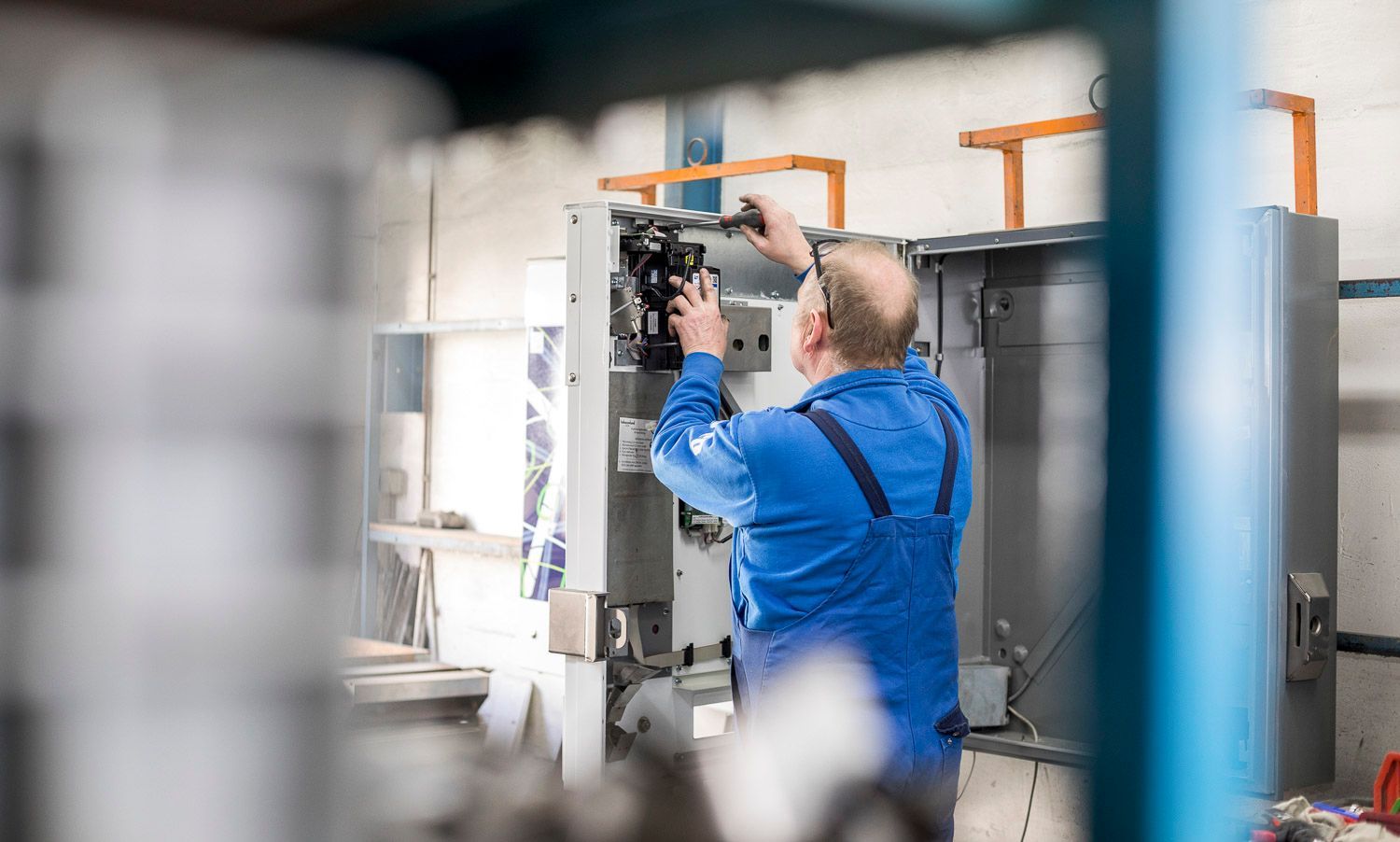 Ein Mann arbeitet in einer Fabrik an einer Maschine.