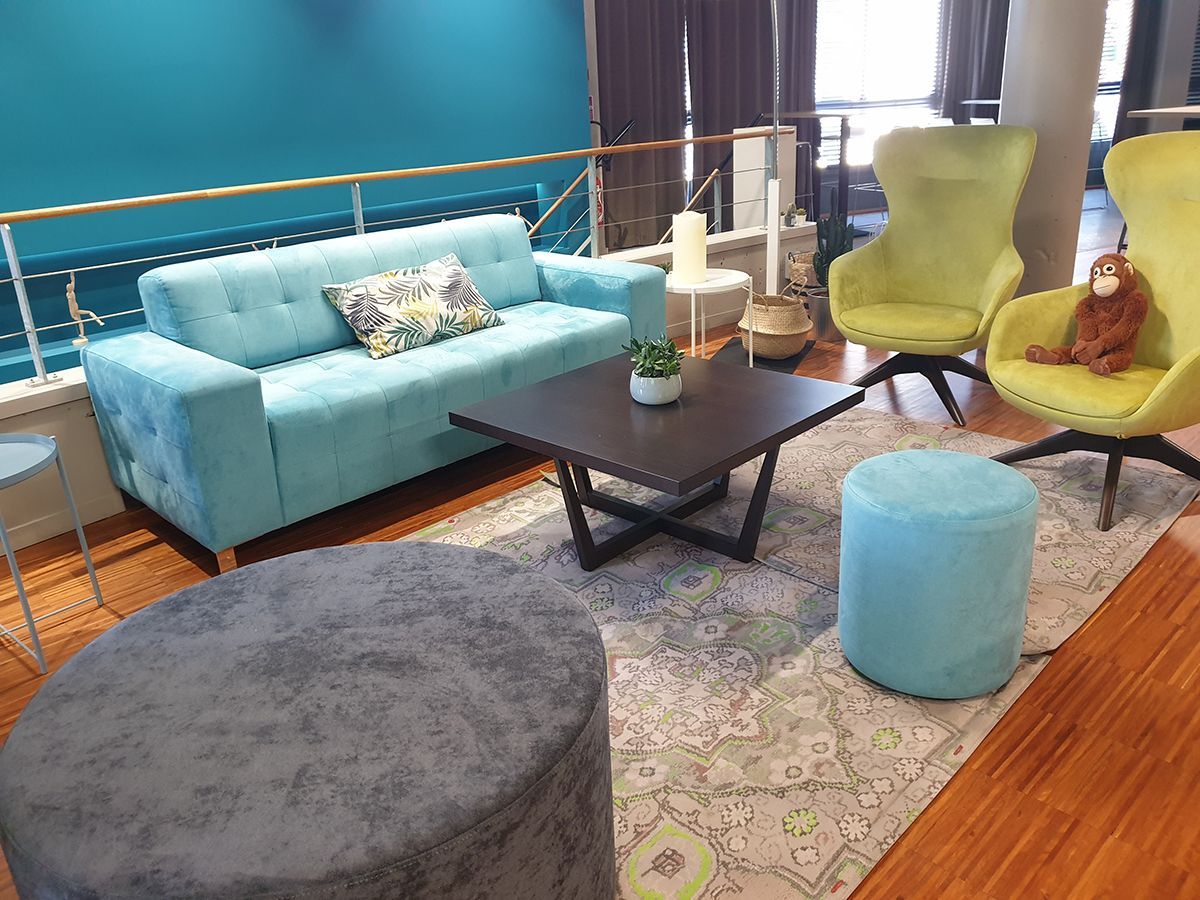 Salon d'accueil du public avec canapé et fauteuils colorés