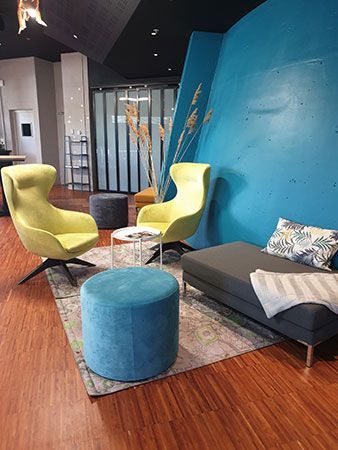 Chauffeuse, poufs et banquette dans un espace de repos coloré