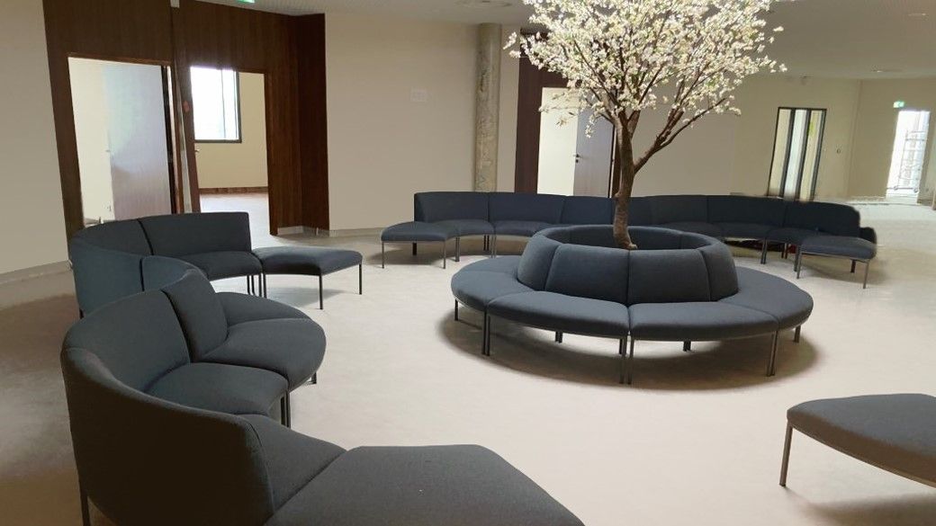 Espace d'attente avec des fauteuils gris et un ilot