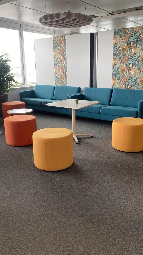 Espace d'attente avec deux canapés bleus et des poufs