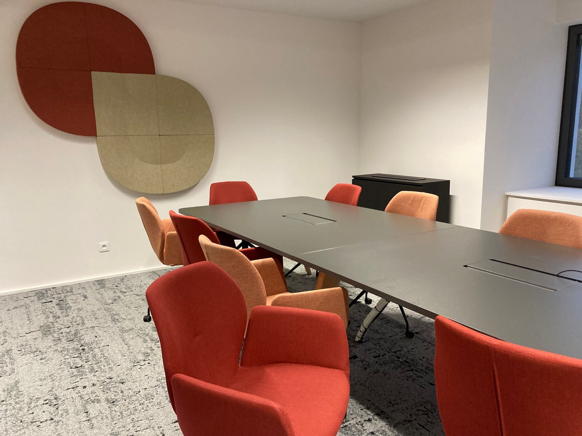 Salle de réunion avec des fauteuils oranges et jaunes