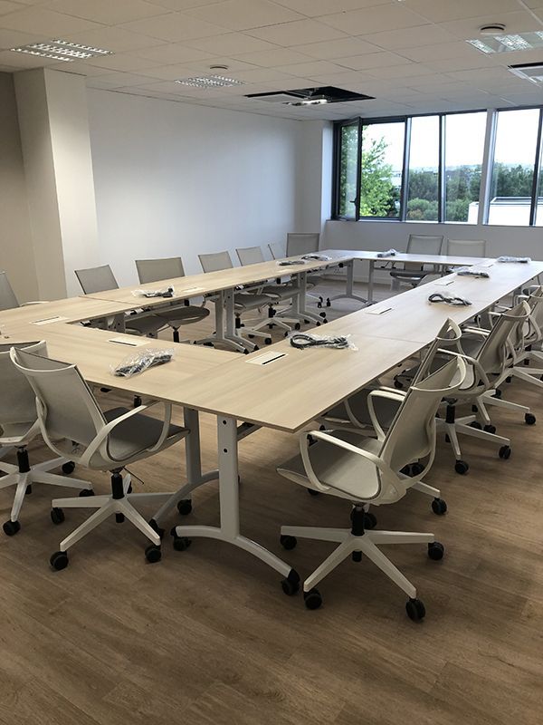 Grande salle de réunion avec table et chaises en rectangle