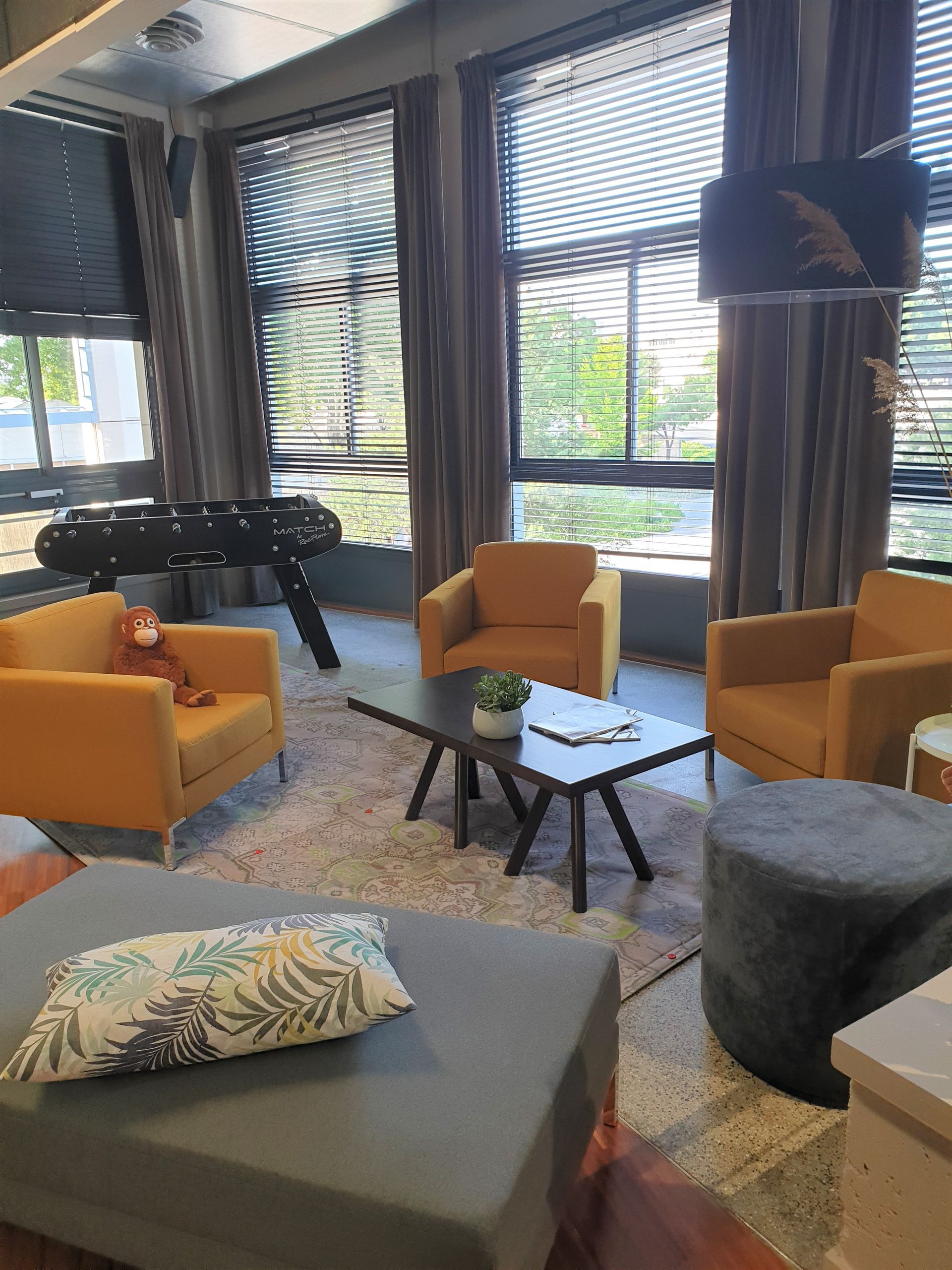 Espace de détente avec fauteuils oranges et babyfoot