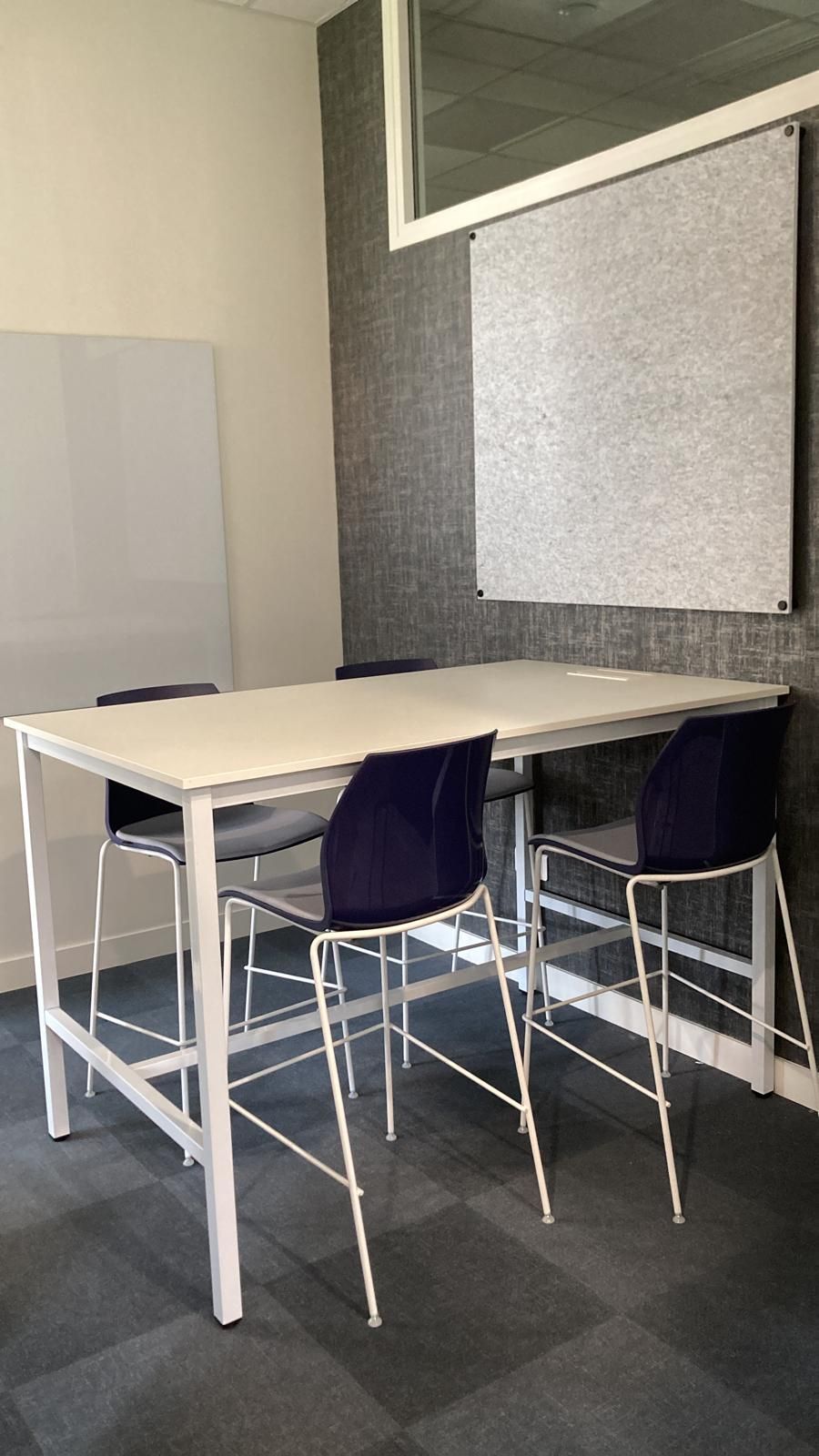 Salle de réunion avec table blanche et 4 chaises