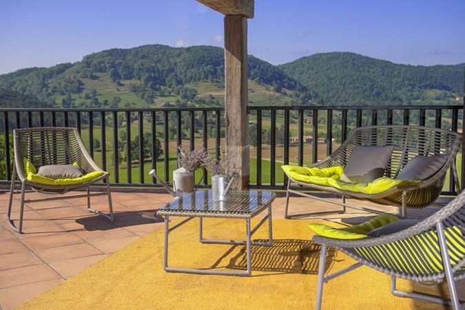 Terrasse avec chaises longues et table basse avec vue sur des montagnes et un fleuve