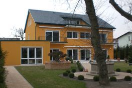 Gelbes Einfamilienhaus mit Vorgarten