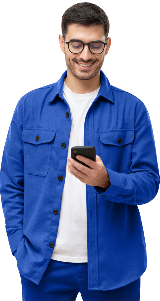 Un homme souriant en veste bleue regarde un smartphone sur fond blanc.