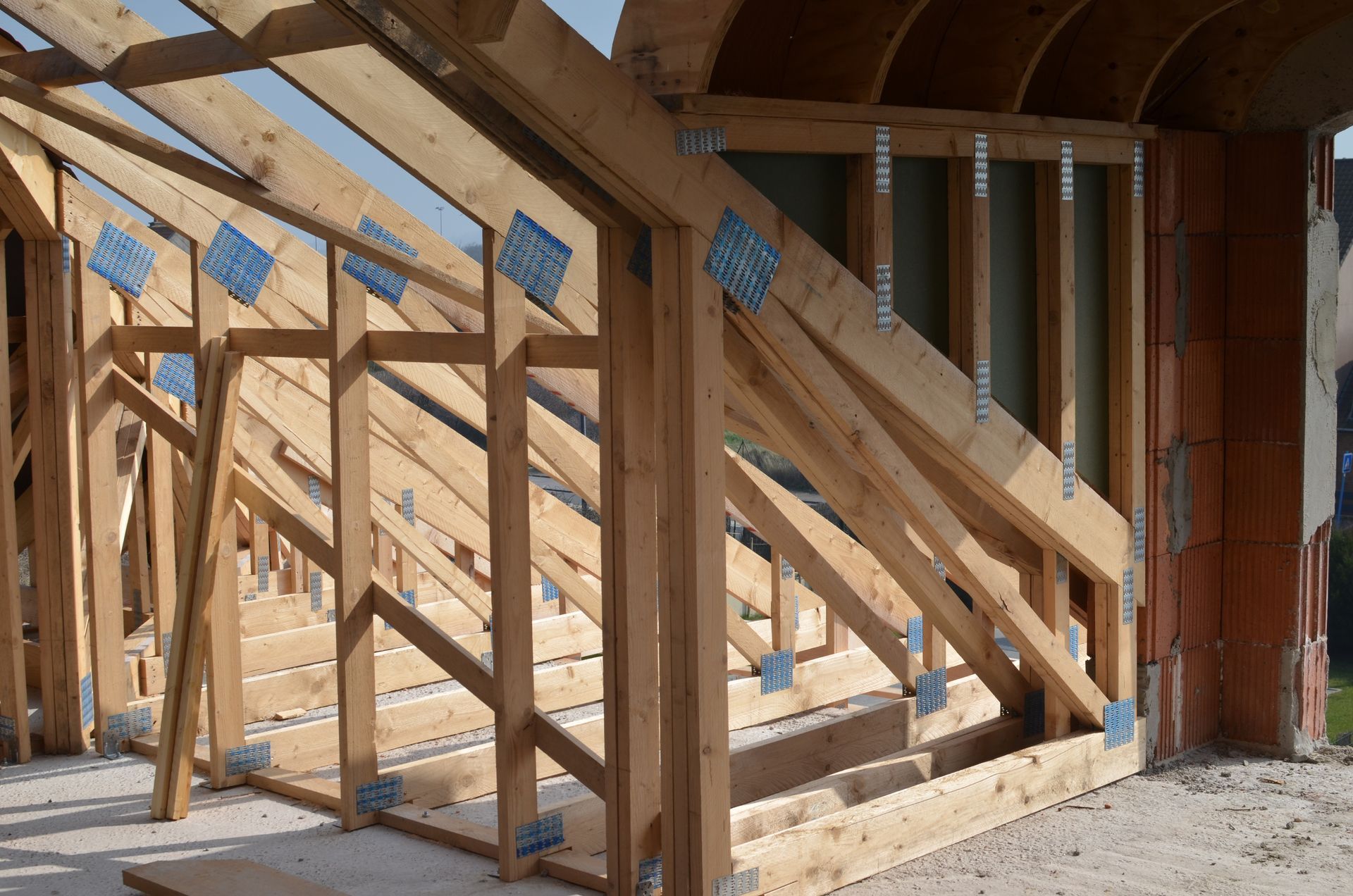 Maison à ossature bois en construction avec des contreventements diagonaux.