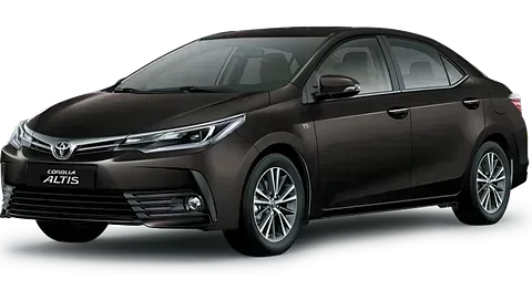 Un sedán Toyota Corolla color marrón oscuro con ruedas plateadas, estacionado al aire libre.