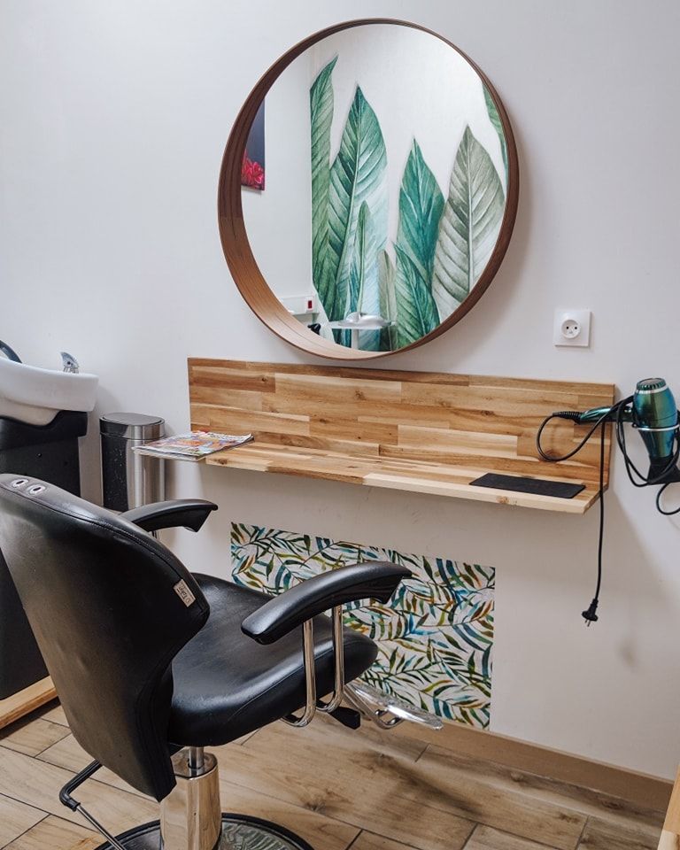 Le salon de coiffure avec un siège noir devant une glace.