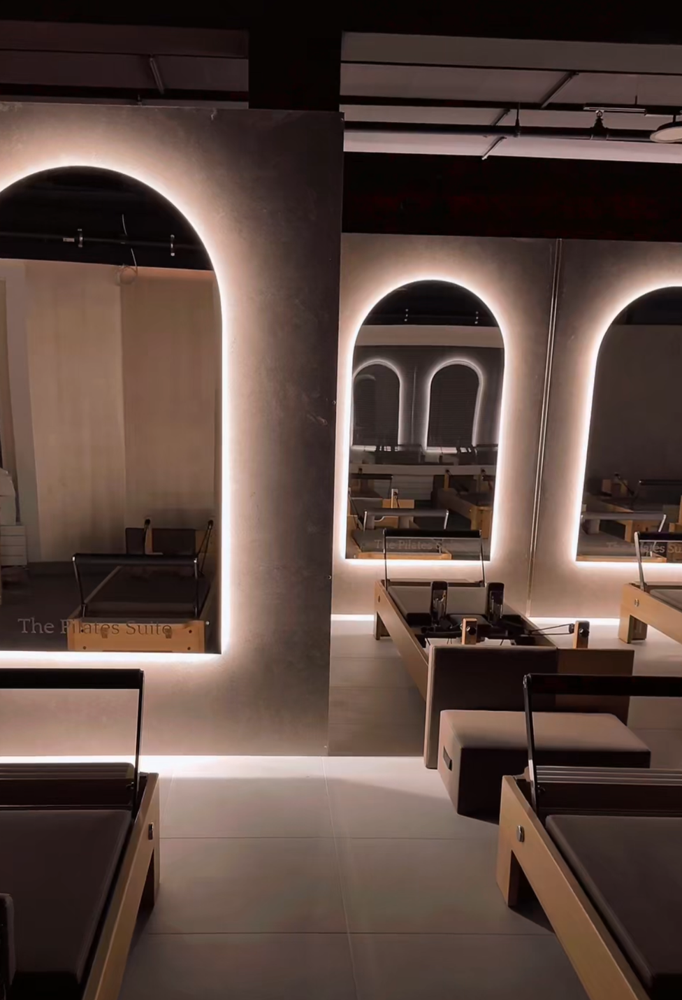 Eine Gruppe von Frauen macht in einem Fitnessstudio Übungen an Pilates-Geräten.