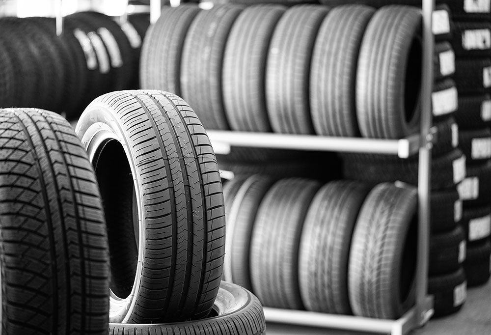 Ein Schwarzweißfoto eines Reifenstapels in einem Reifengeschäft.