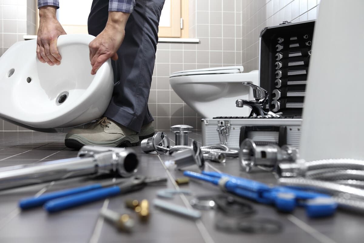 Un fontanero está instalando un lavabo en un baño.