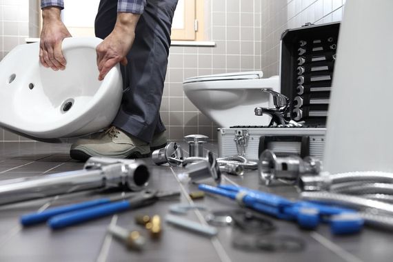 Un fontanero está instalando un lavabo en un baño.