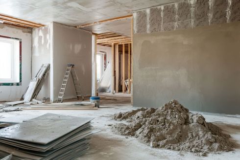 Una habitación en construcción con una pila de cemento en el suelo.