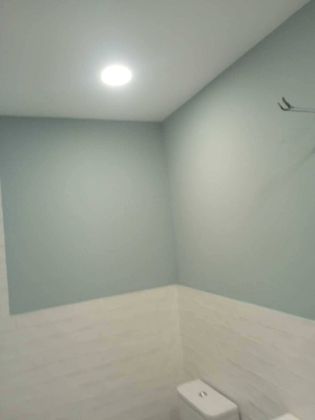 Un baño con inodoro y una luz en el techo.