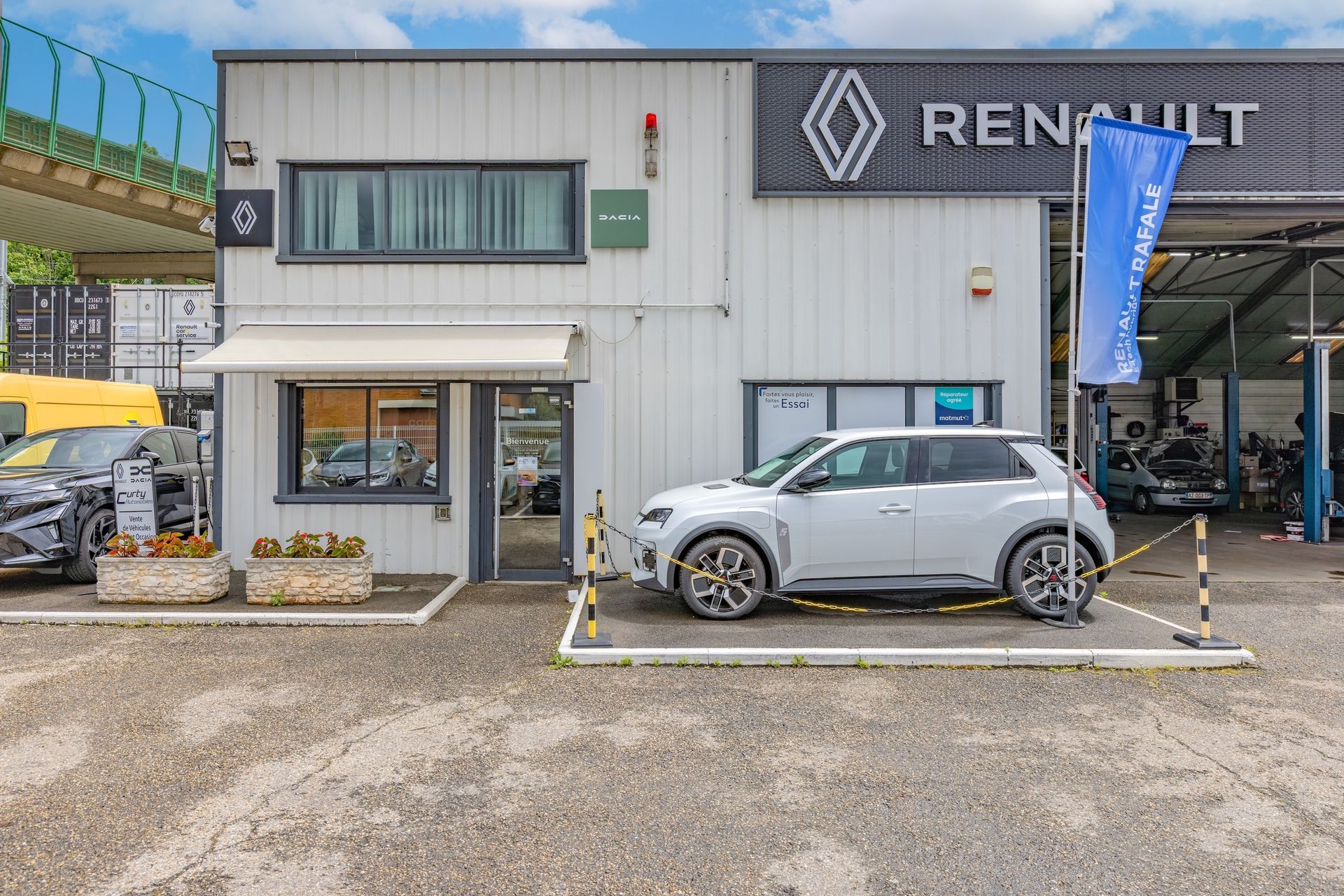 Un véhicule Dacia garé devant un garage