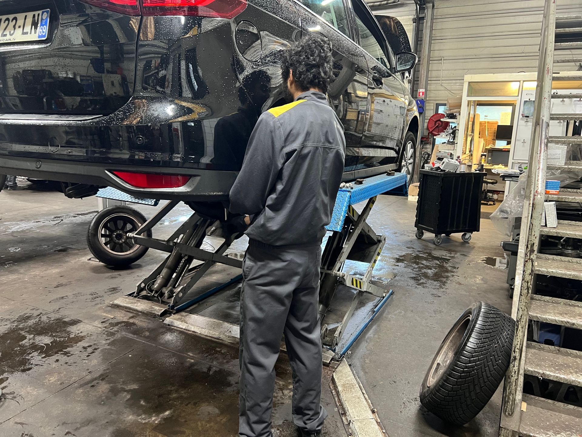 Un homme en train de démonter une roue de voiture