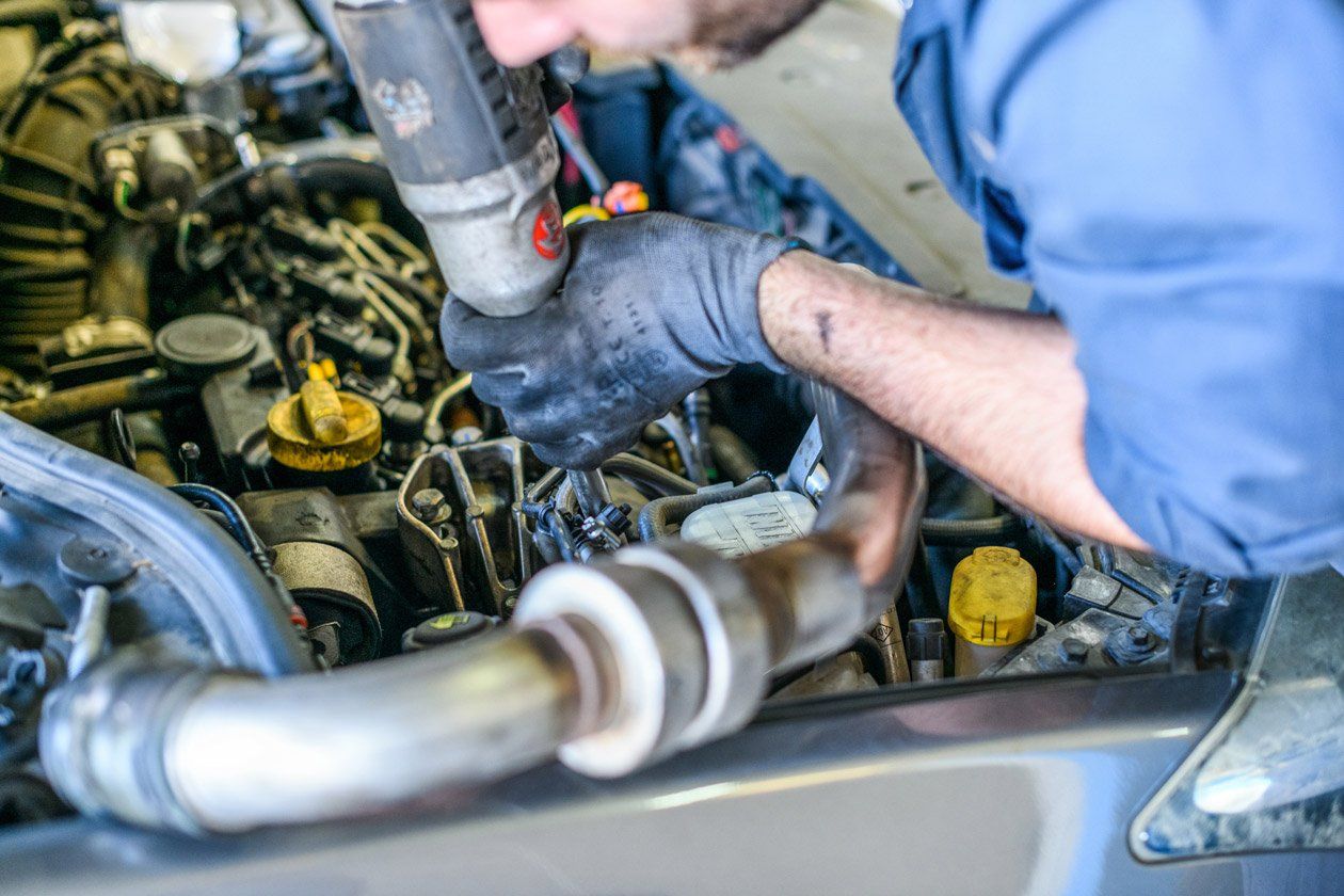 Un professionnel de la mécanique travaille sur un moteur de voiture