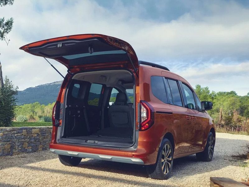 Un Renault Kangoo rouge avec le coffre arrière ouvert