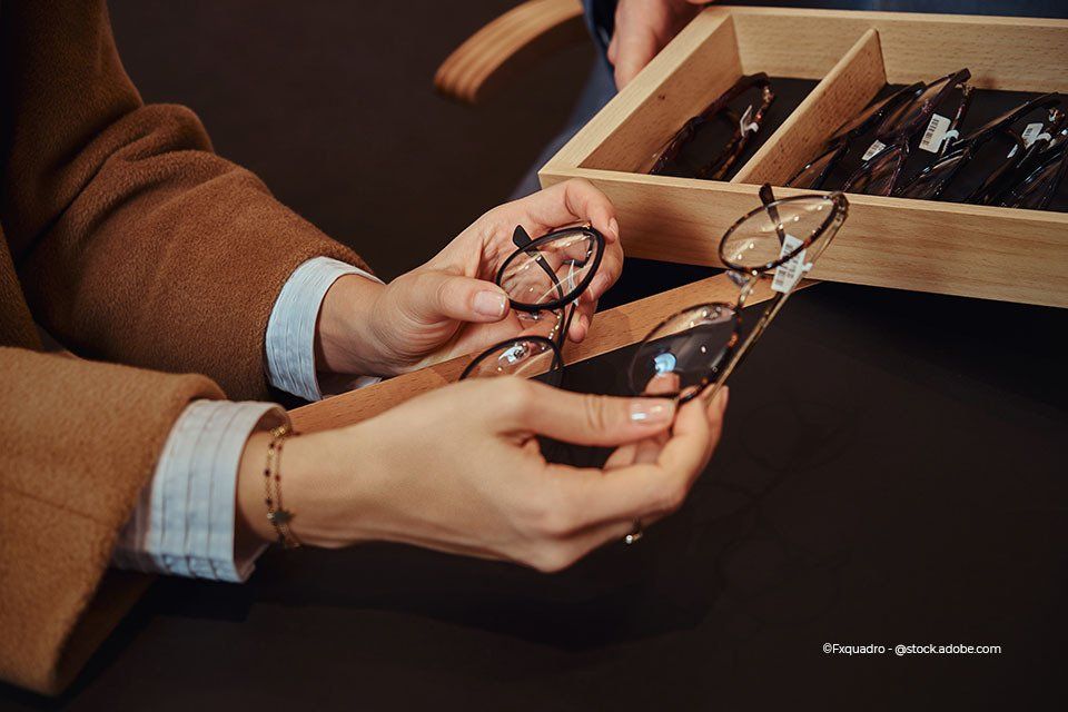 Ein Kunde von Kaden Carmen-Sylvia Augenoptik Kaden hält verschiedene Brillen in der Hand