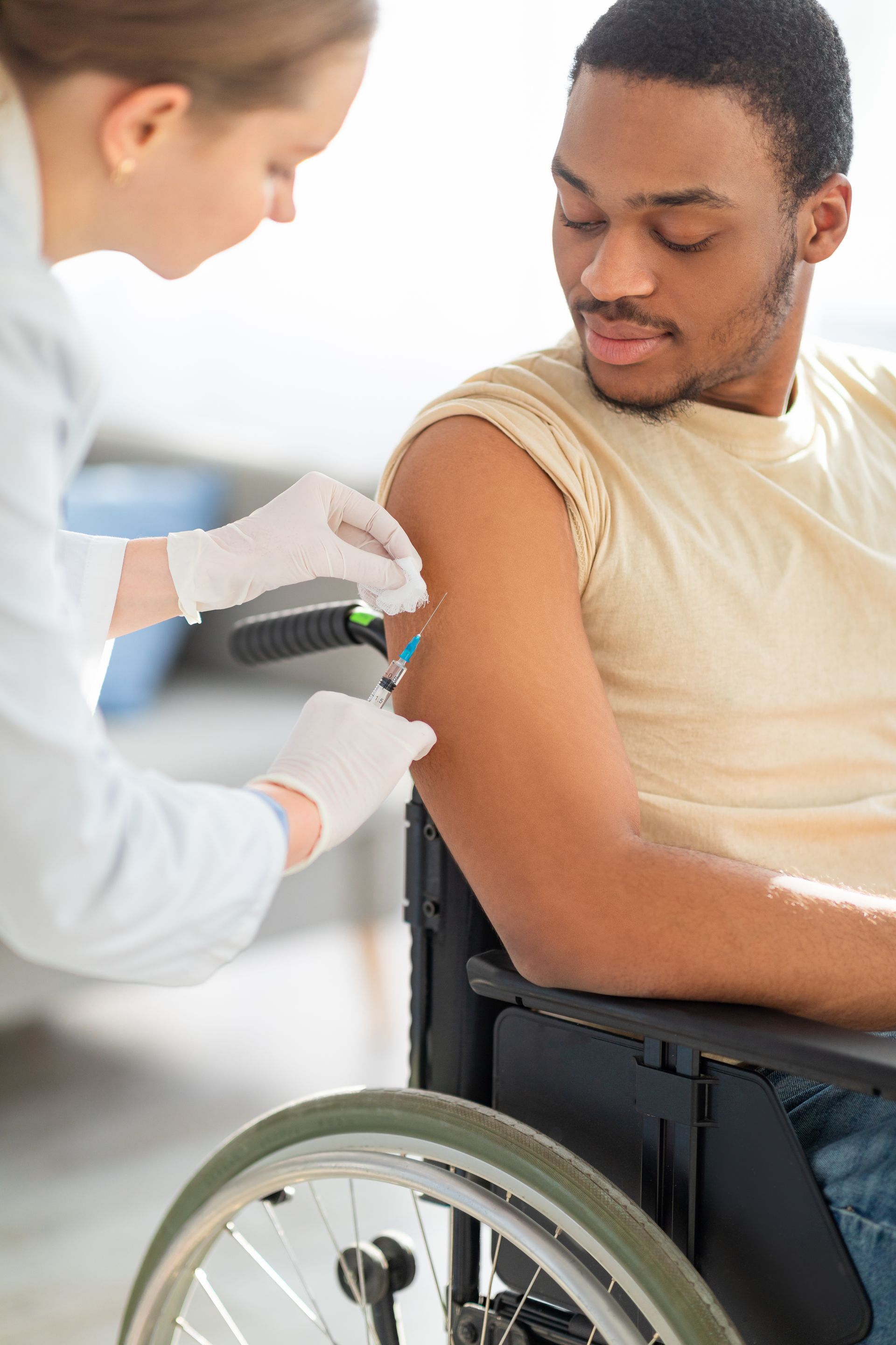 Injection sur un patient en fauteuil roulant