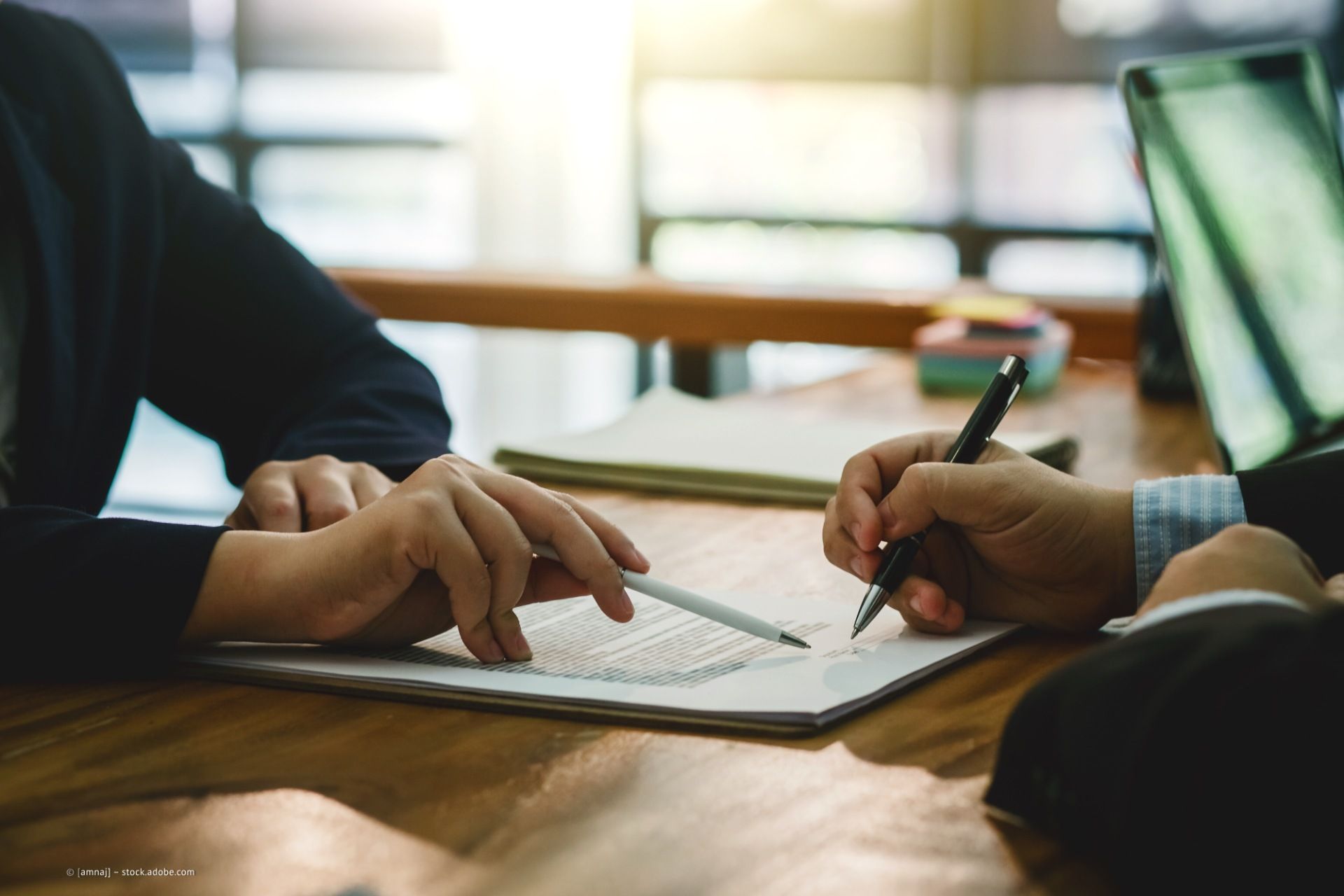 Person zeigt auf ein Dokument, das in einem Klemmbrett steckt