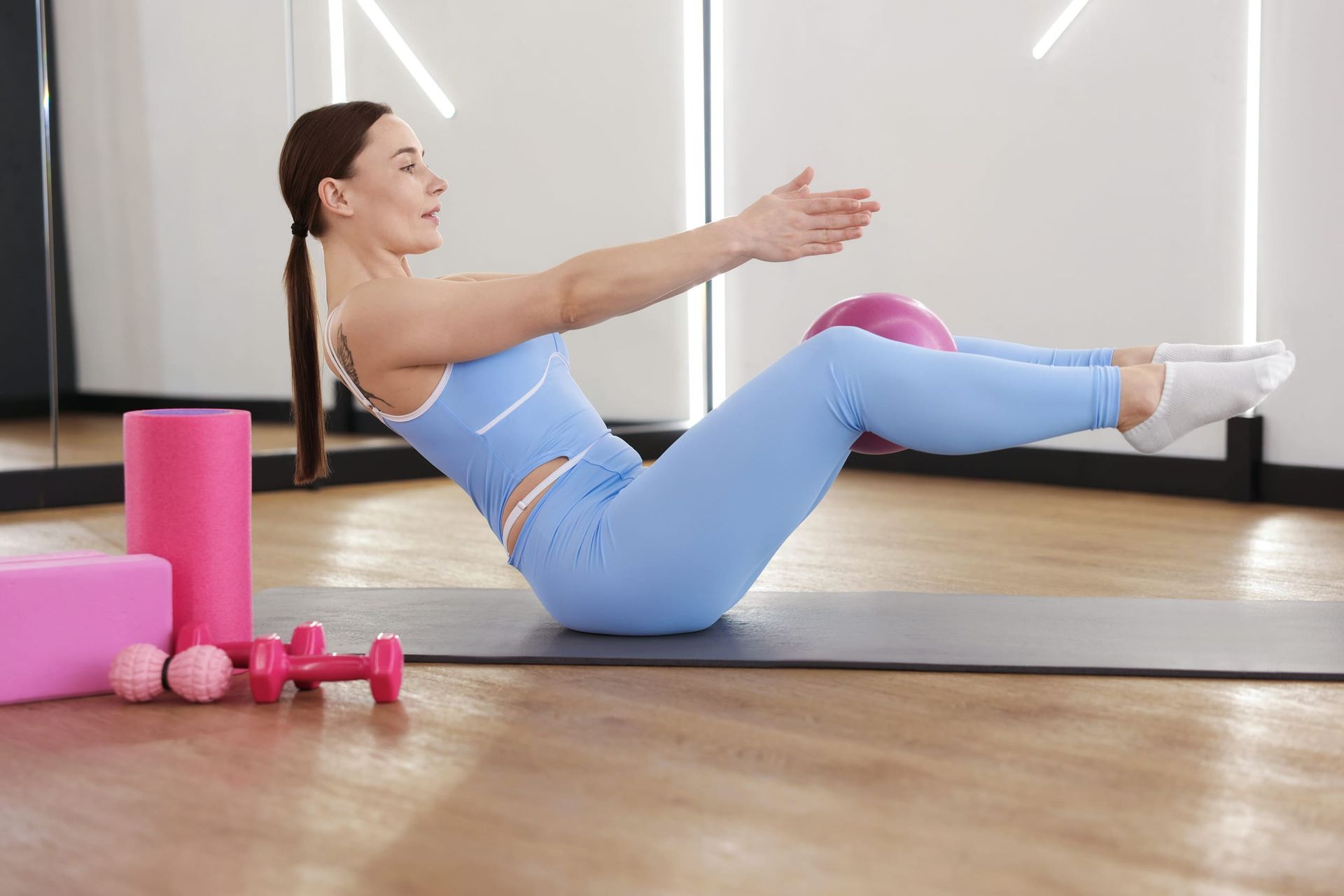 Personas realizando ejercicios de puente de glúteos con placas de pesas en un gimnasio.