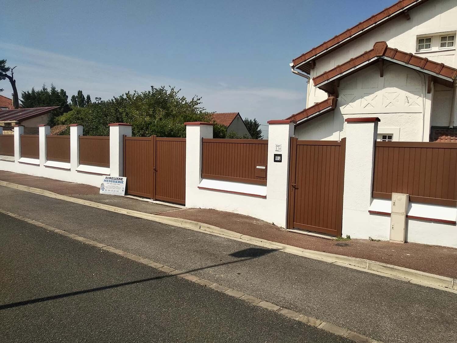 Clôture en bois avec muret et des portails en bois