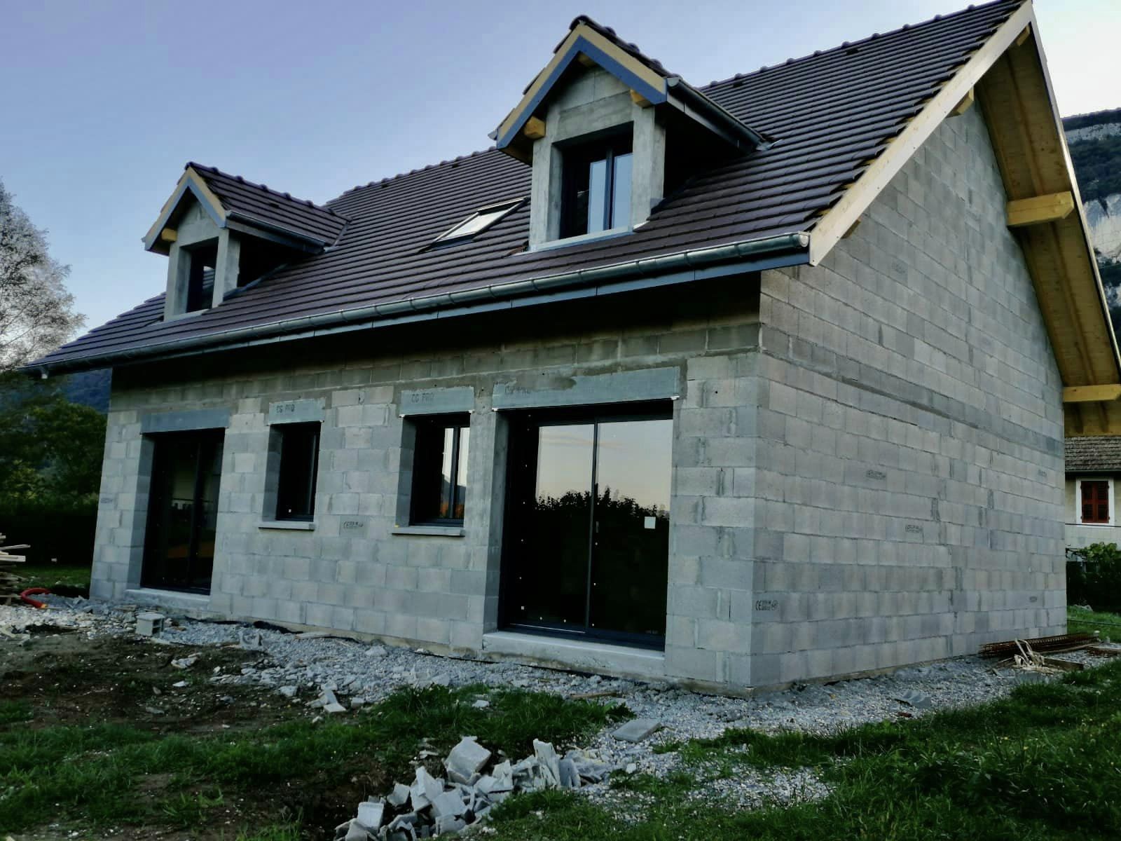 Maison en construction avec des fenêtres et des portes installées