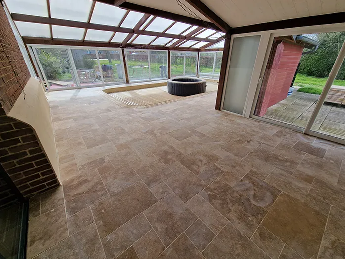 Travaux de terrasse dans une grande pièce vitrée