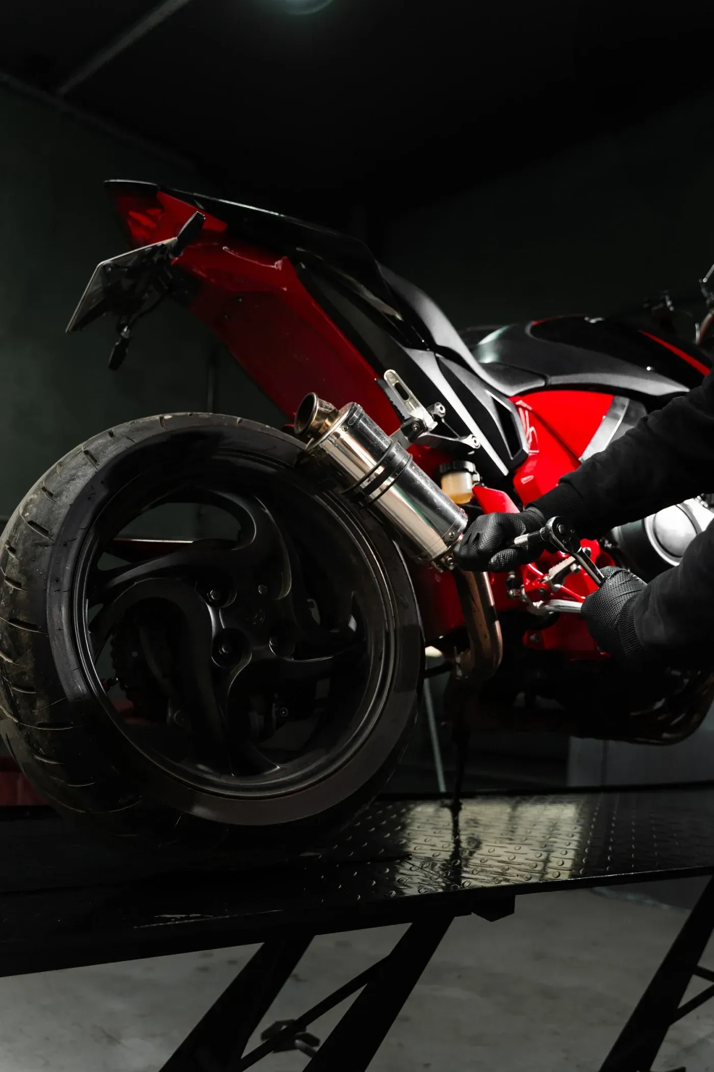 Una motocicleta roja y negra en reparación en un garaje.