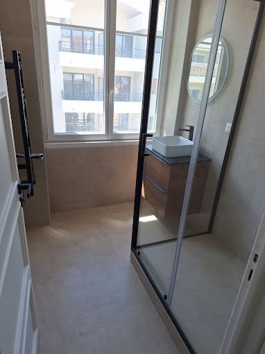 Salle de bains avec douche italienne et grande fenêtre