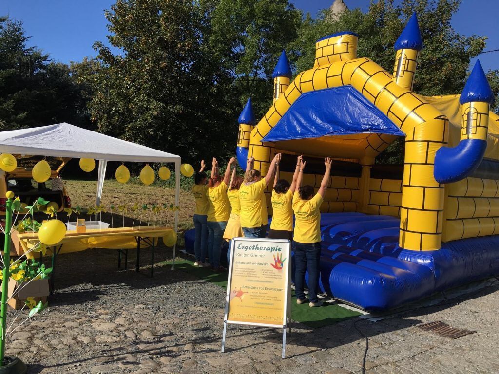 Ergotherapeuten stehen vor einer Hüpfburg