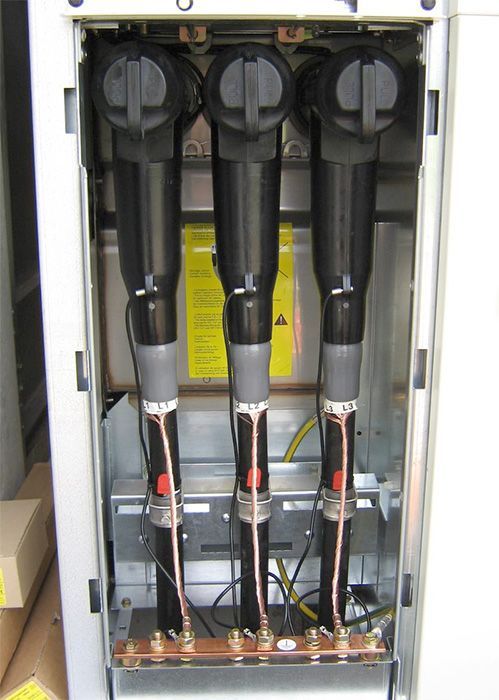 ein elektrischer Schaltschrank mit drei Kabeln und einem Schild darauf