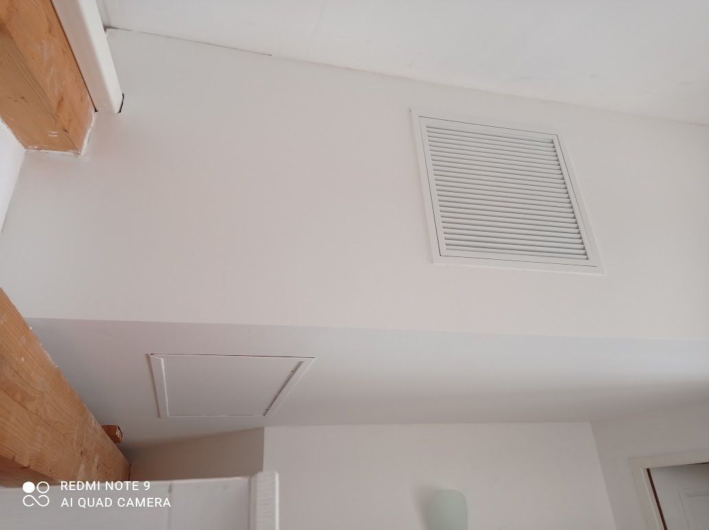 Plafond avec grille d'aération et panneau d'accès.