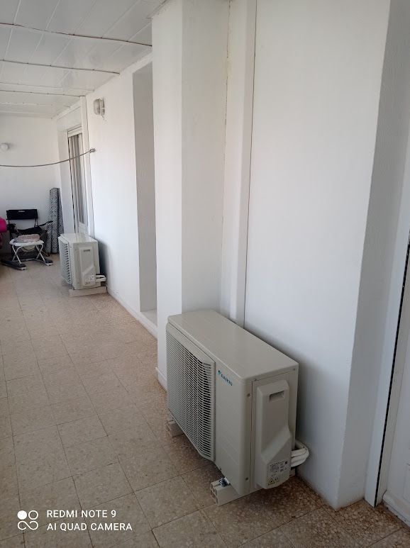 Couloir avec deux climatiseurs le long du mur.