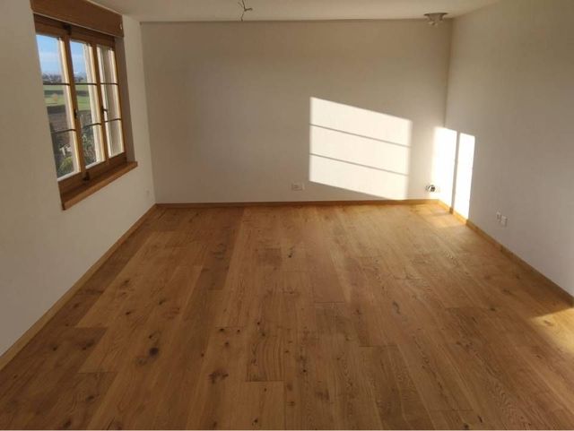 Holzstämme bilden neben einem überdachten Arbeitsbereich Beete für die Bepflanzung im Freien.
