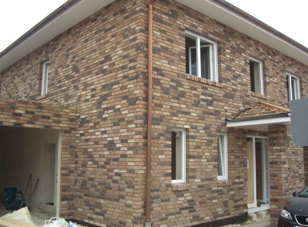 Ein Backsteinhaus mit einem davor geparkten Auto