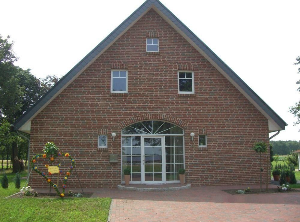 Ein großes rotes Backsteinhaus mit einem schwarzen Dach